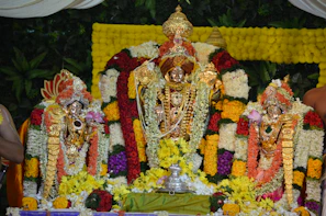 A peaceful scene of a green and yellow altar for Oxum, decorated with honey and bright flowers.