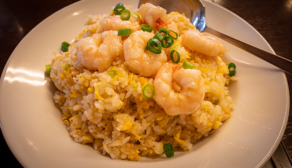 a white plate topped with rice and shrimp