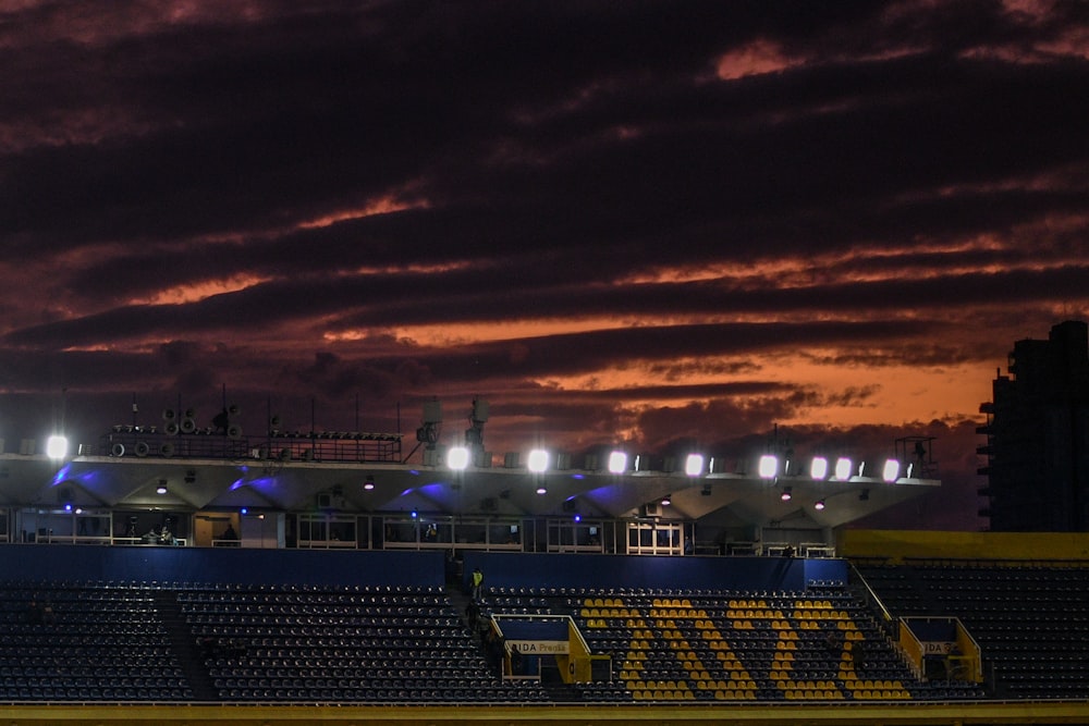 a plane is flying over a stadium at night