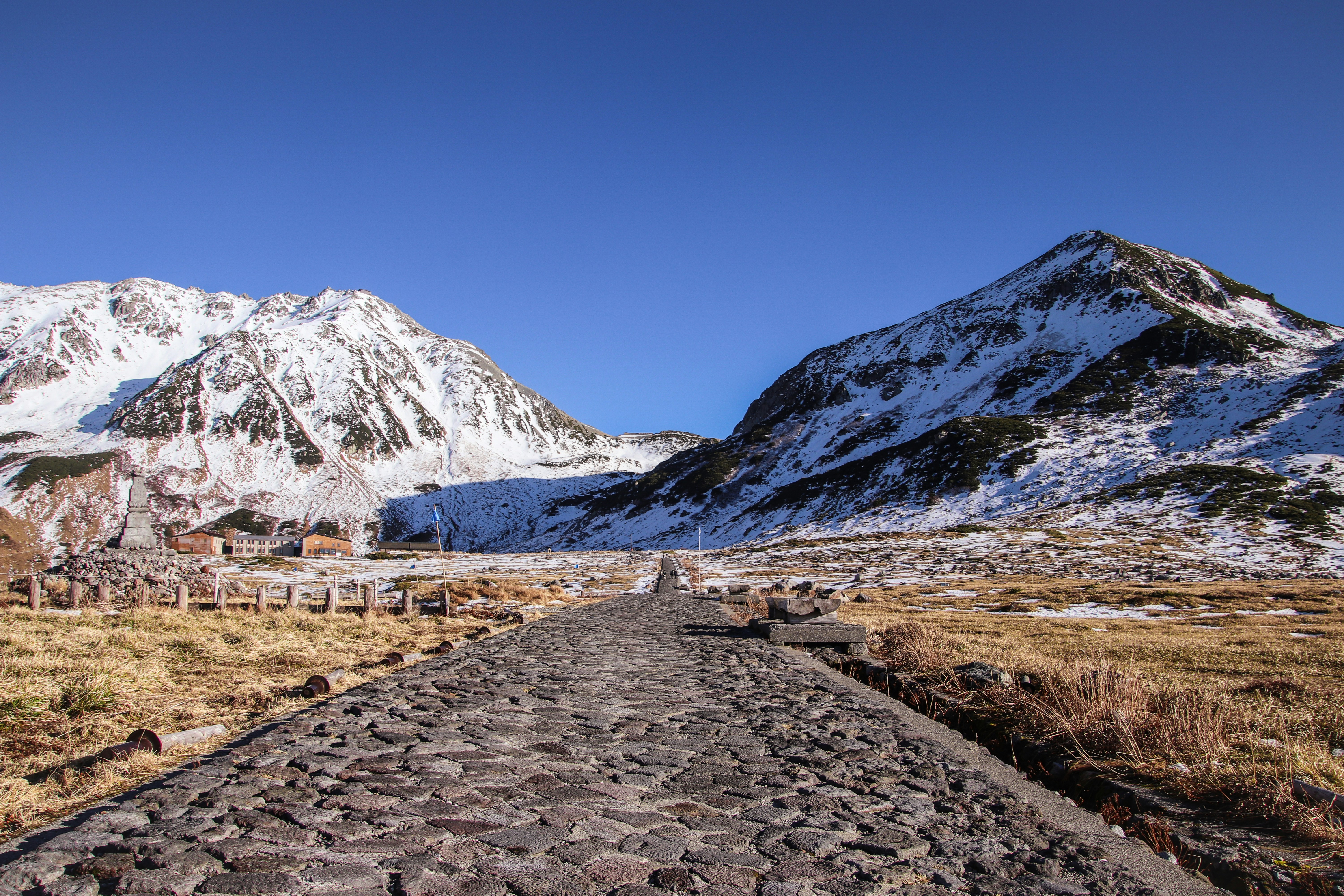 ein Feldweg vor einem Gebirgszug