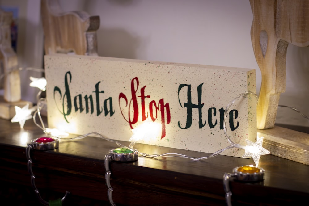 a wooden sign that says santa stop here