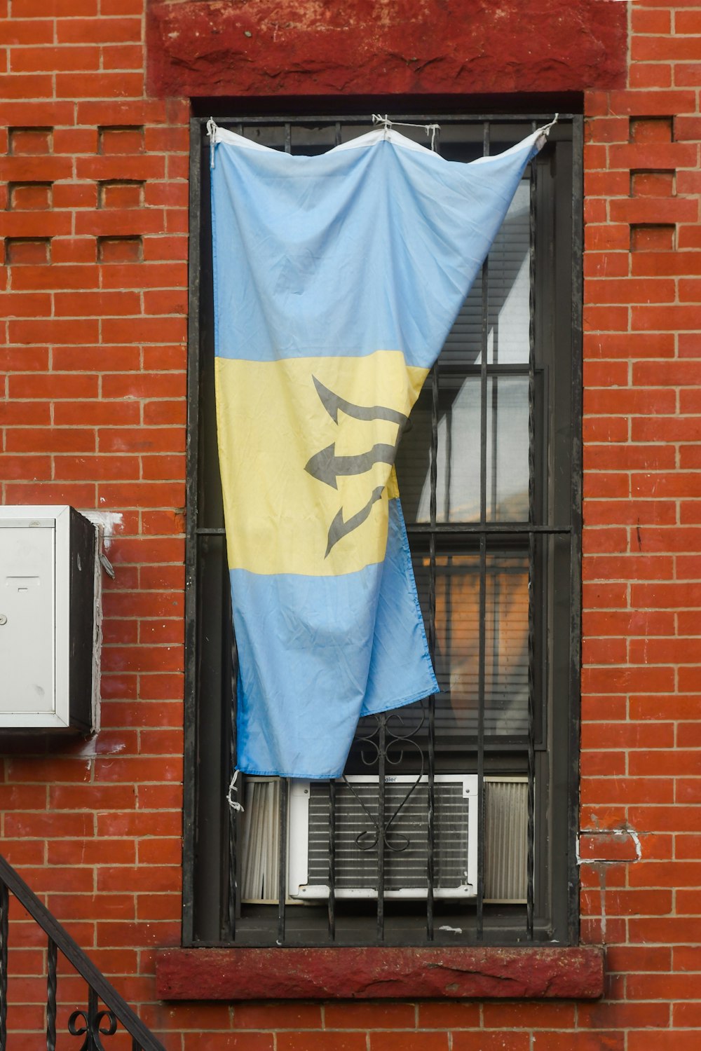 a blue and yellow flag hanging out of a window