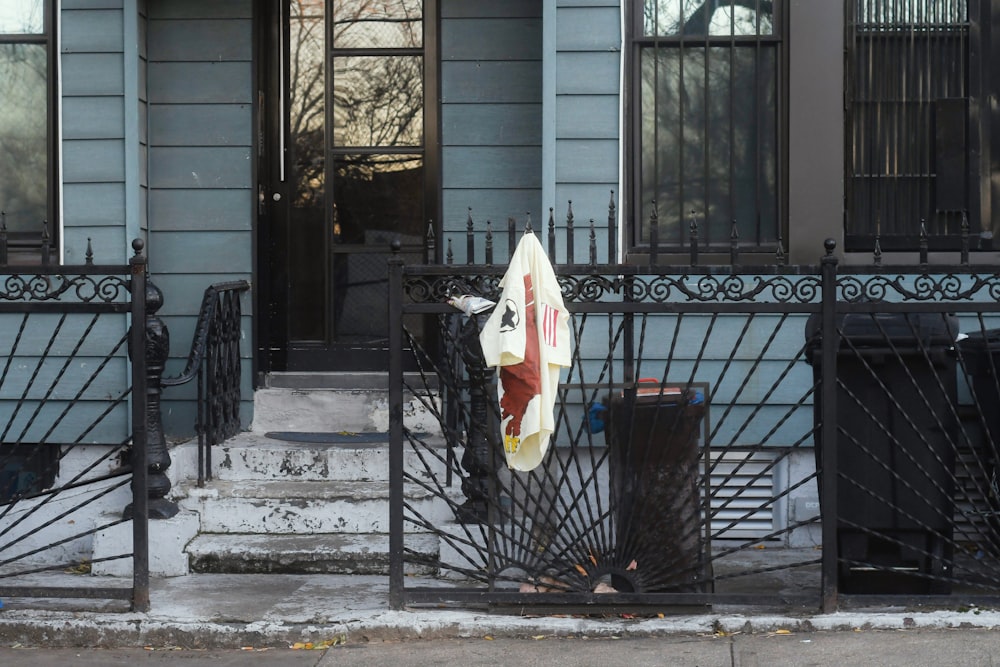 a surfboard leaning against a gate in front of a house