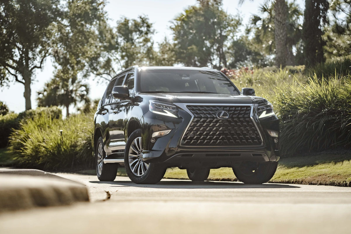 A black luxury SUV parked at dusk with warm bokeh lights