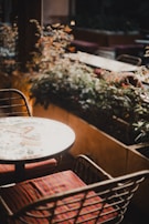 An outdoor scene featuring a mosaic table surrounded by chairs.