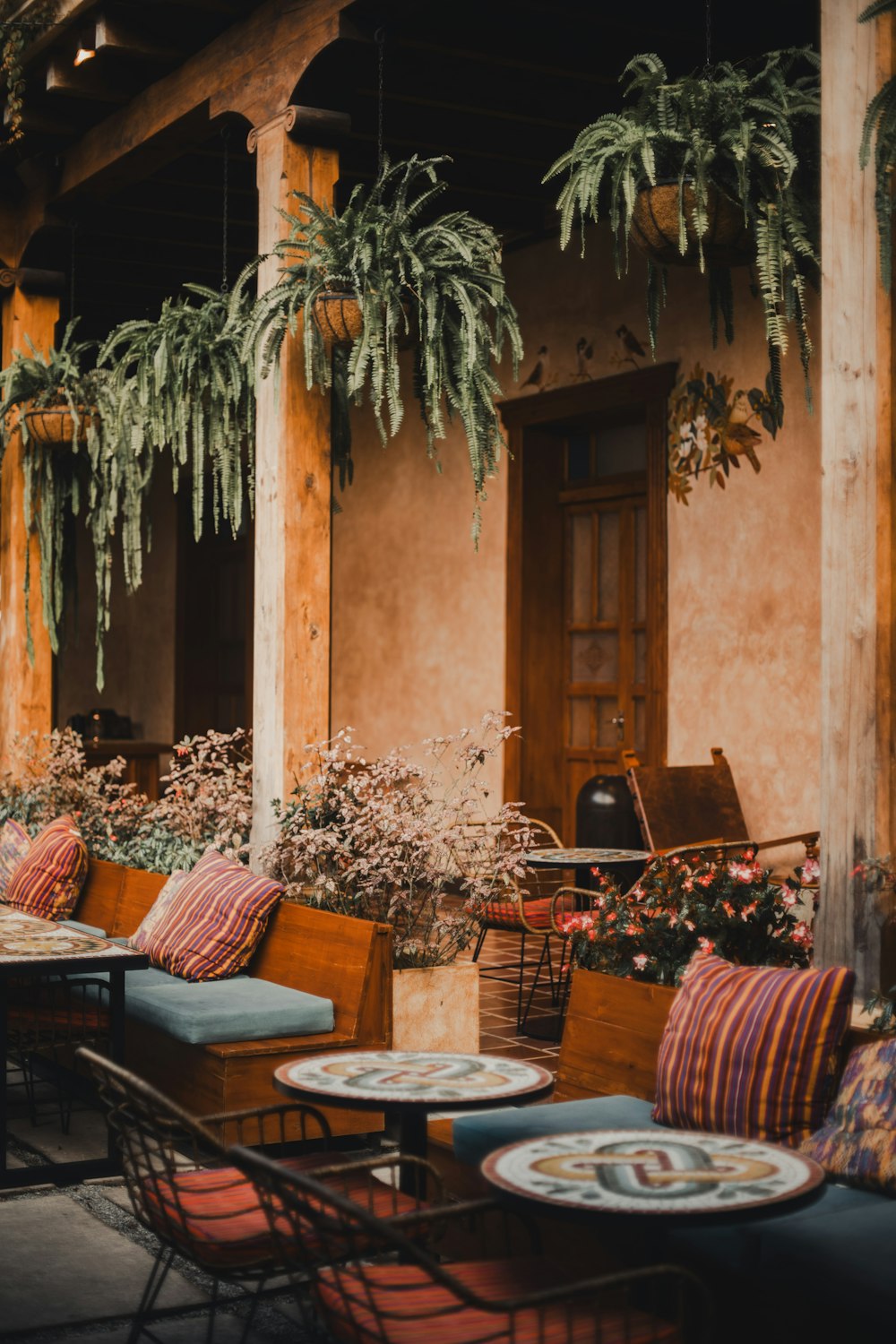 a patio area with tables and chairs and potted plants