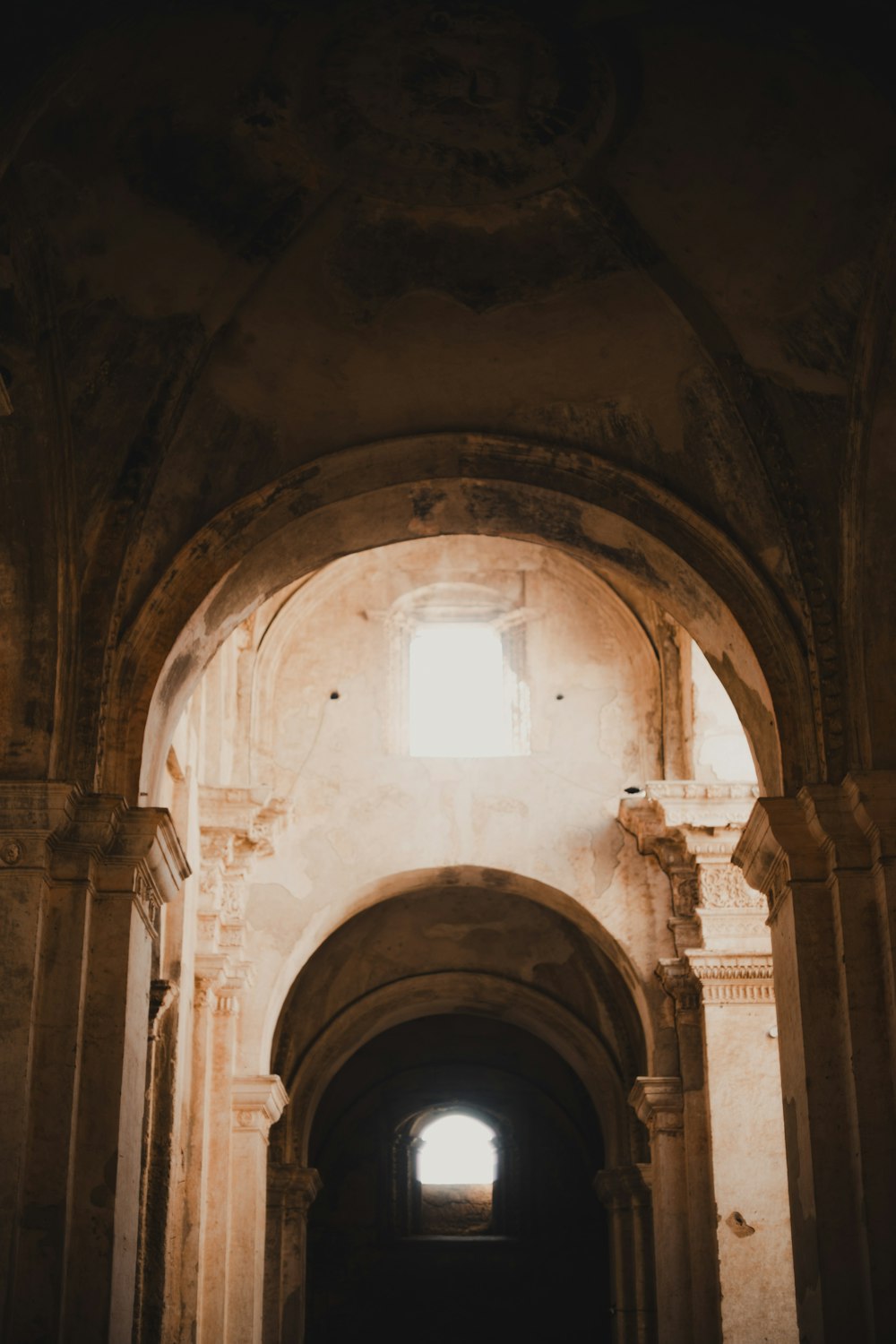 an archway in a building with a light coming through it