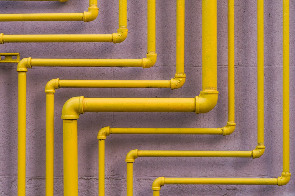 a close up of yellow pipes on a wall