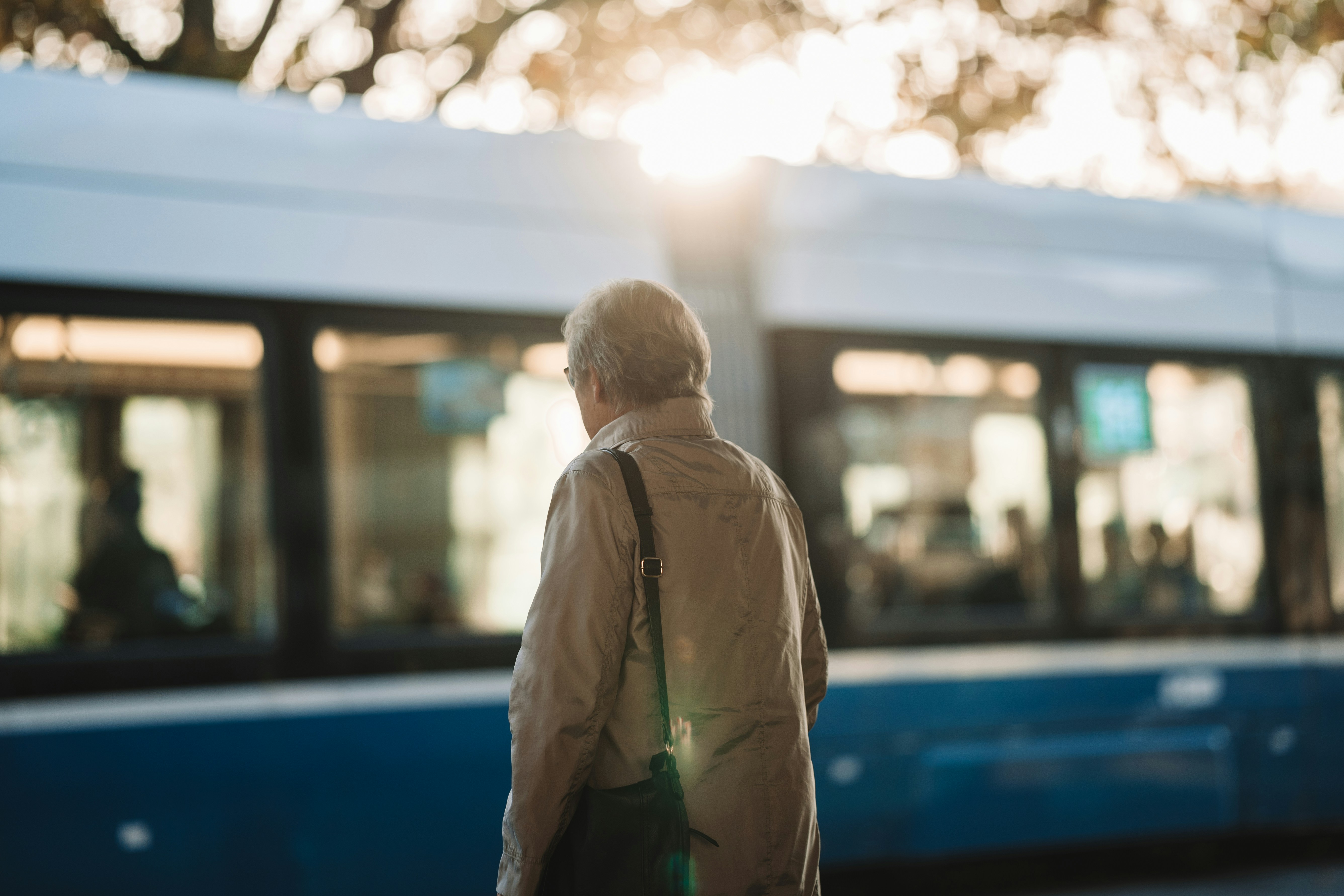 a man standing in front of a blue and white train