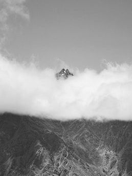 A black and white photo of a majestic mountain peak against a clear sky, symbolizing strength and achievement.