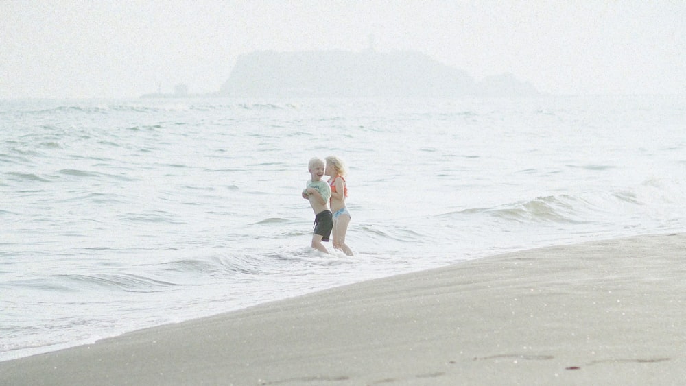 a couple of people that are standing in the water