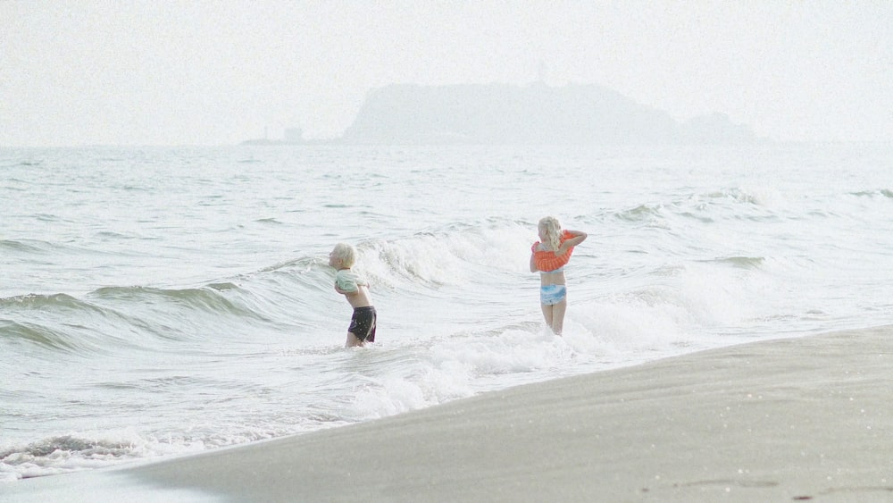 a couple of people that are standing in the water