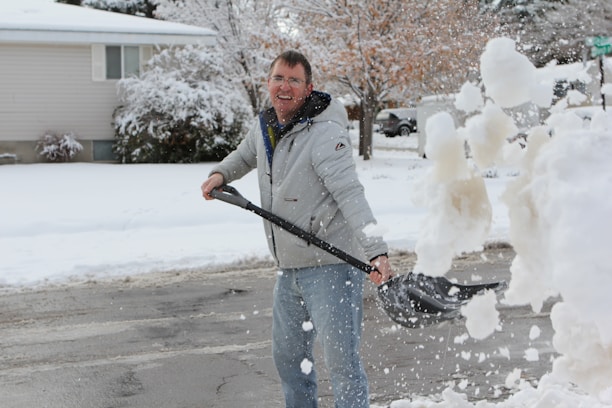 Jason Frost clearing snow with a friendly smile in a snowy Spring Creek neighborhood.