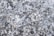 A textured surface featuring a gray, speckled pattern typical of stone or concrete. The irregular shapes and shades of gray create a natural, rugged appearance.