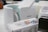 A Cricut mug press is displayed alongside a Cricut box featuring decorative designs for mugs, as well as other devices in the background. The scene seems to be set in a workspace or creative area.