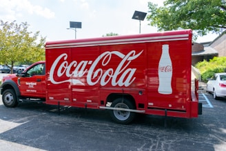 a coca - cola truck parked in a parking lot