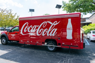 a coca - cola truck parked in a parking lot