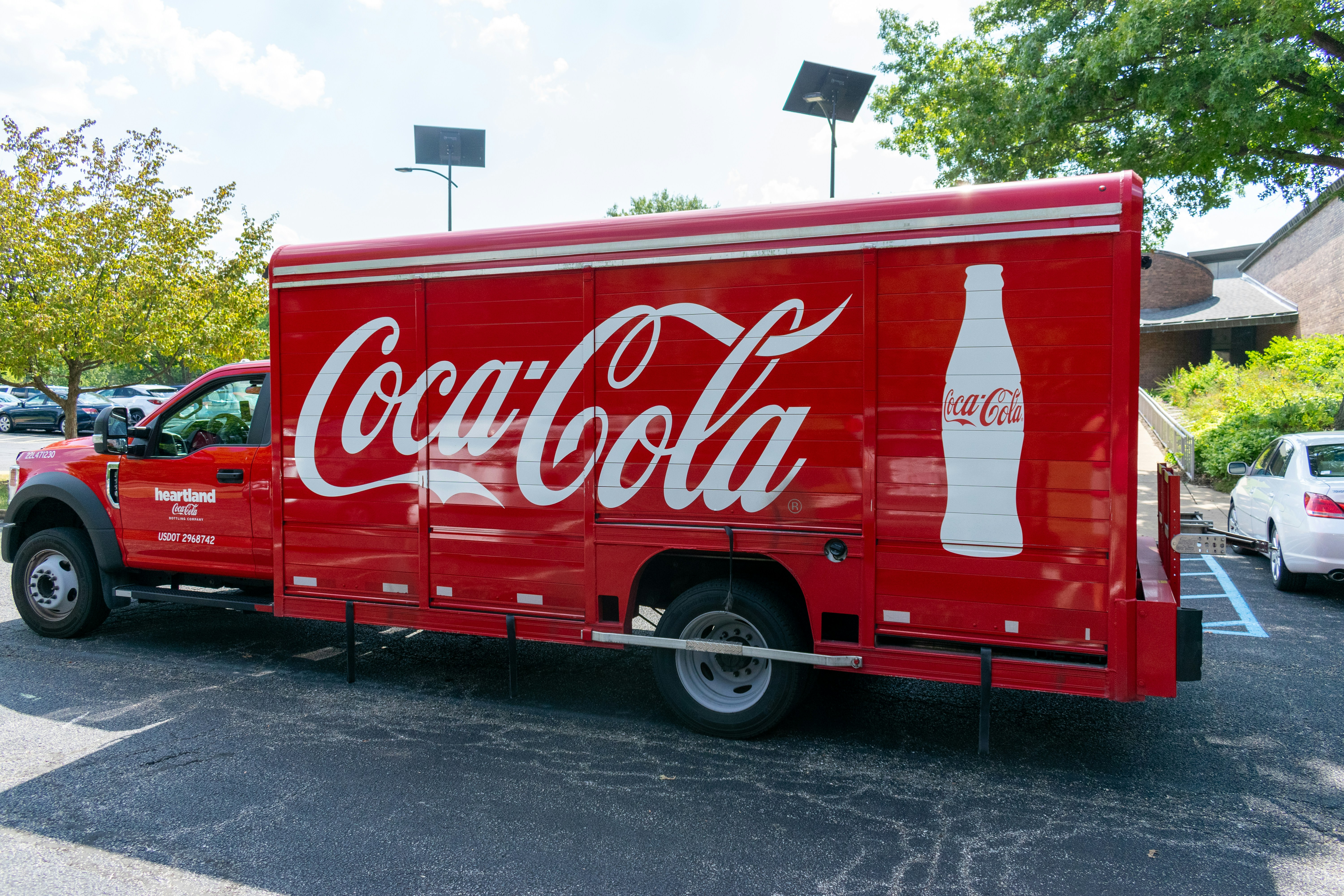 a coca - cola truck parked in a parking lot