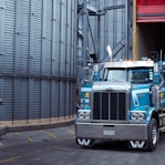 a large blue truck parked in front of a building