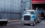 a large blue truck parked in front of a building