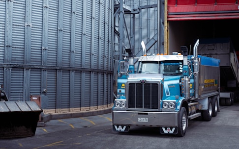 a large blue truck parked in front of a building