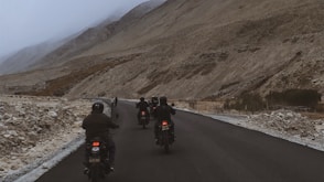 a group of people riding motorcycles down a road