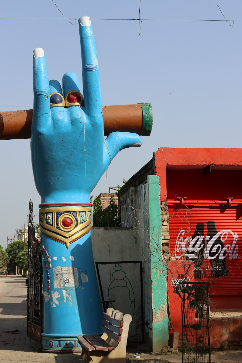 a statue of a hand holding a skateboard in front of a building