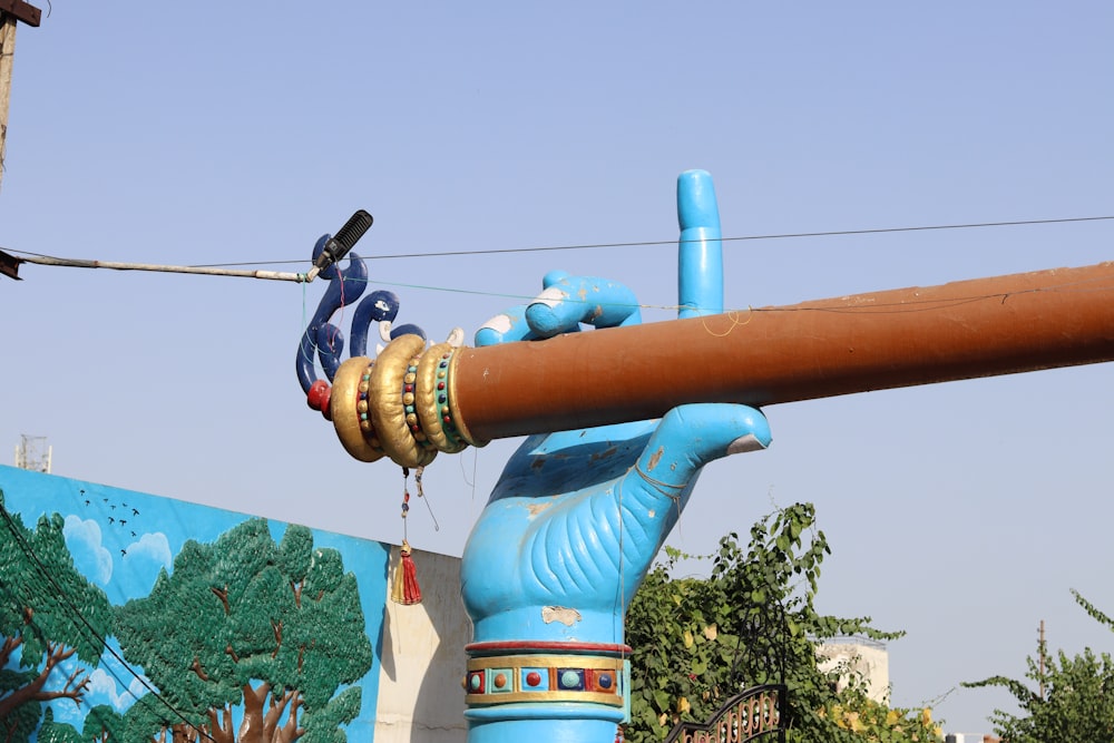 a blue sculpture of a hand holding a pipe