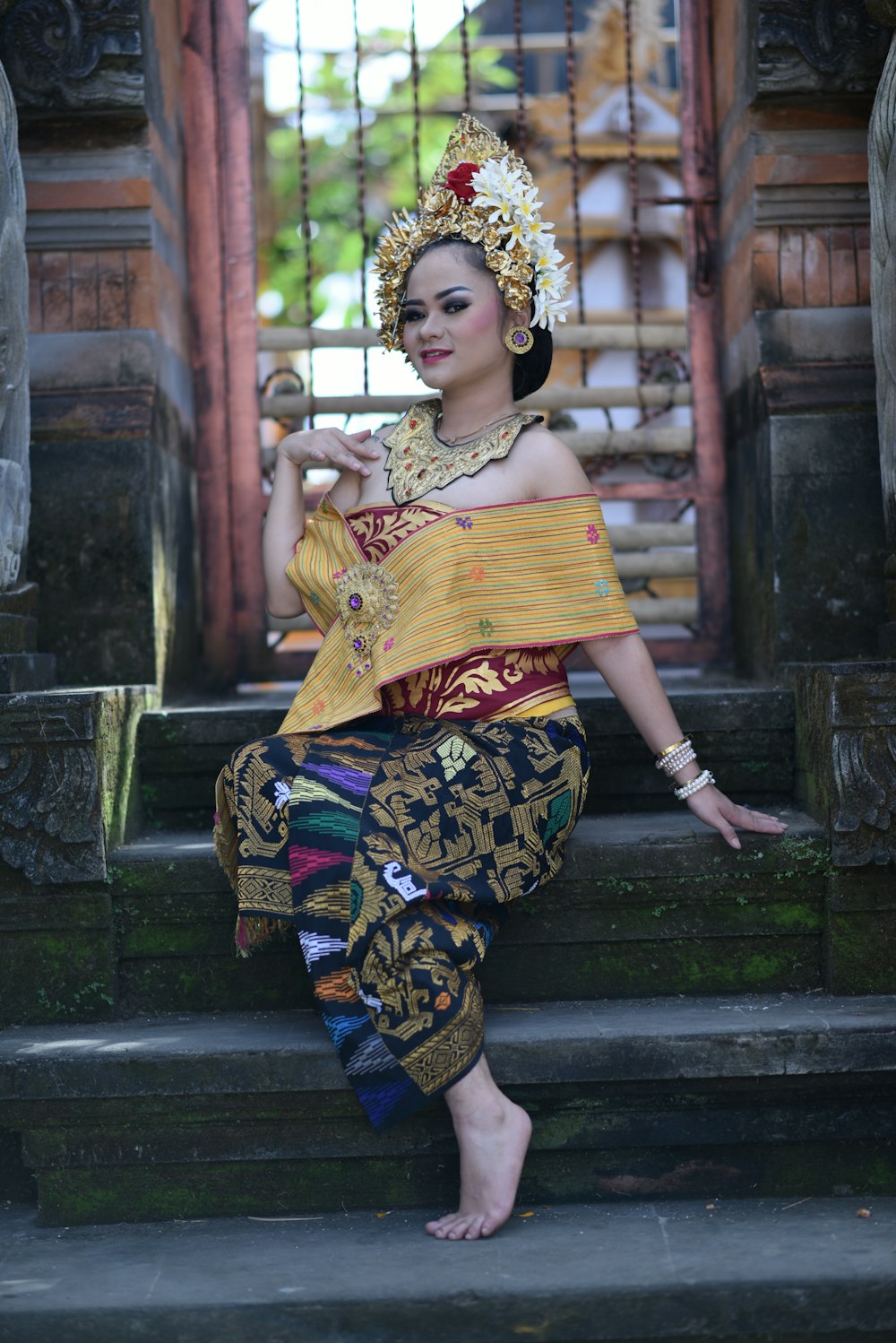 a woman in a traditional thai costume poses on some steps