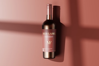 A single wine bottle with a red label against a matching red background. The label features the words 'Red Label' and 'MF' with a subtle shadow of the bottle cast on the surface.