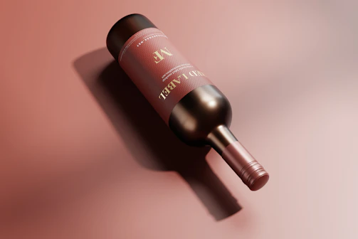 Elegant bottle of red wine with a golden label resting on a black marble surface.