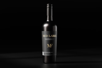 a bottle of red wine on a black background