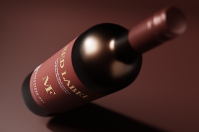 A close-up view of a wine bottle lying on its side. The label on the bottle is prominently displayed, featuring text that includes 'Red Label'. The bottle cap and the label are in shades of red and brown, with a smooth and glossy appearance.