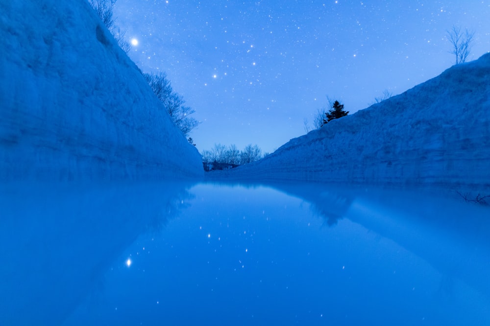 Un cuerpo de agua con un cielo lleno de estrellas