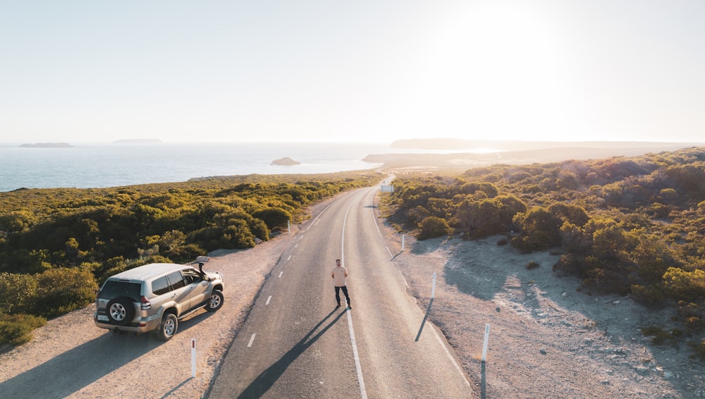 a truck driving down a road next to the ocean