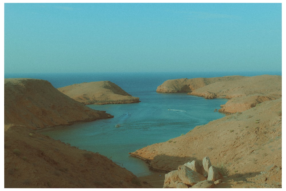 a body of water surrounded by rocky hills