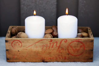 Rustic gift box with handmade candle and avocado honey jar on wooden table at sunset in Axarquía.