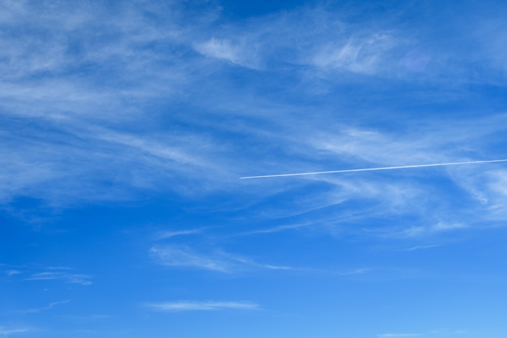 una persona volando una cometa en un cielo azul