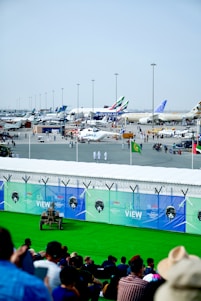 A vibrant scene of planes lined up at Munich Airport with enthusiasts watching and photographing the aircraft.