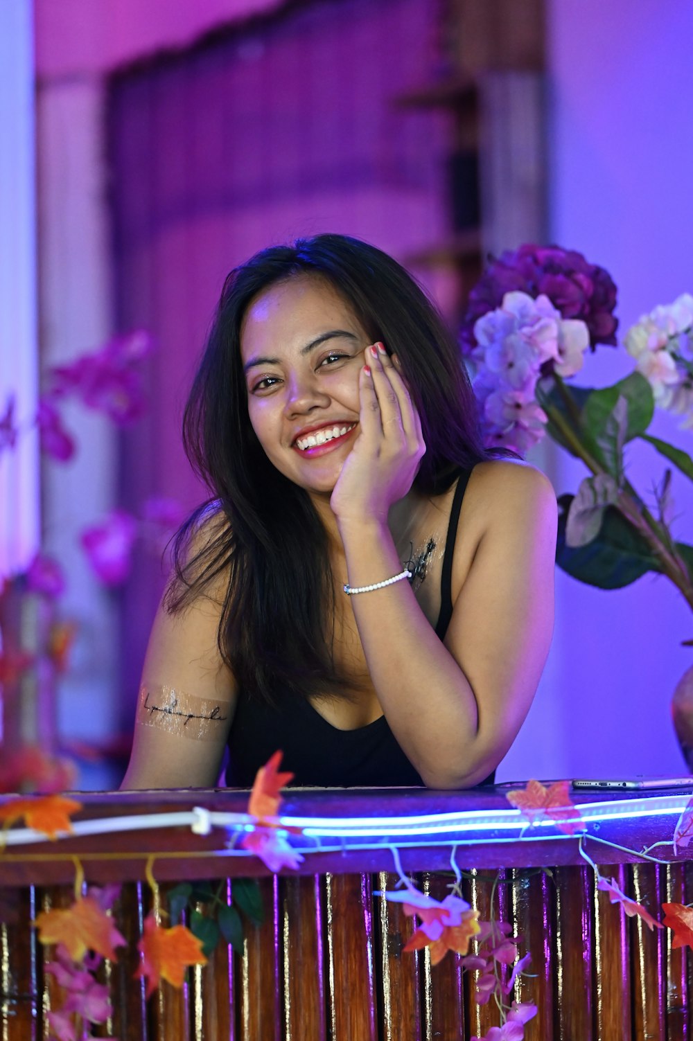 a woman smiling and holding her hand to her face