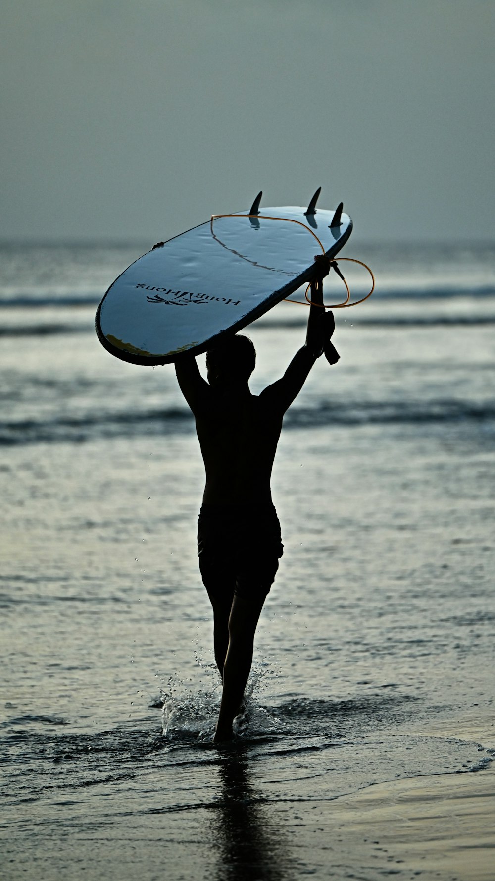 a man carrying a surfboard into the ocean