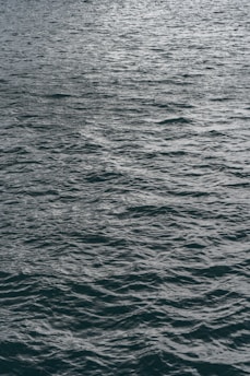 a large body of water with a boat in the distance