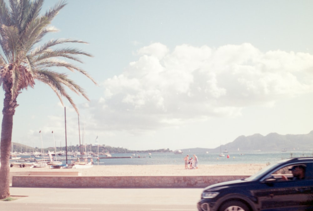 a car driving down a street next to a beach