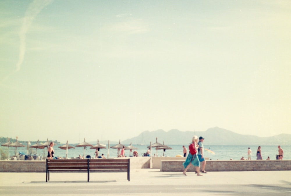 a group of people walking along a beach next to the ocean