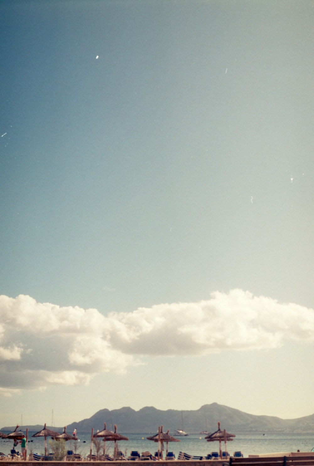 a large body of water sitting under a cloudy blue sky