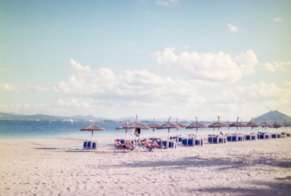 une plage de sable avec des parasols et des chaises