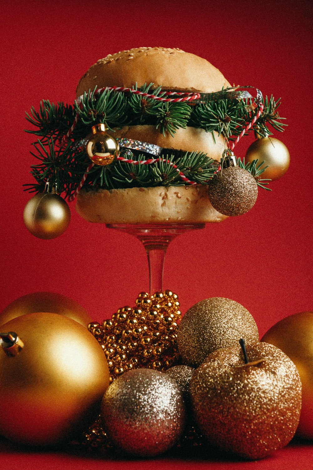 a hamburger and christmas ornaments on a red background