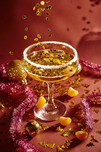 Colorful cocktail being poured into a stylish glass at a festive event.