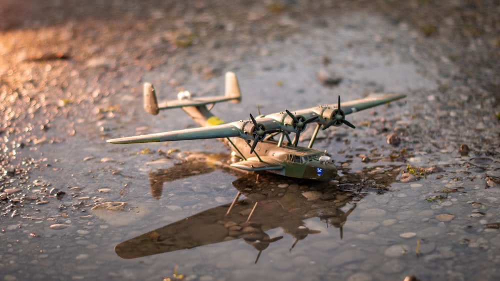 a toy airplane sitting on top of a puddle of water