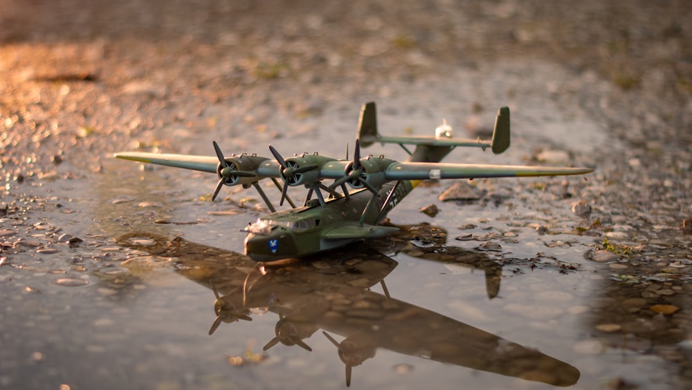 un modèle réduit d’avion assis au-dessus d’une flaque d’eau
